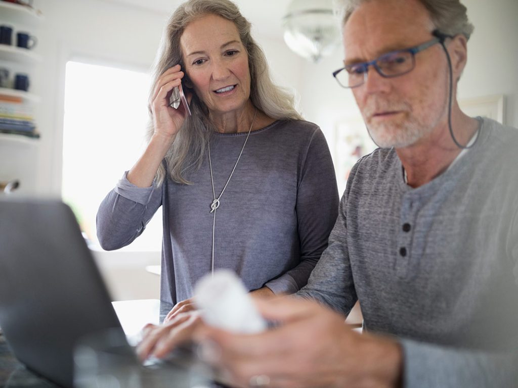 Woman and man looking at bottle and speaking on telephone