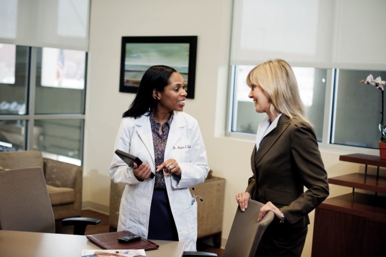 physician and admin meet in doctors office 1